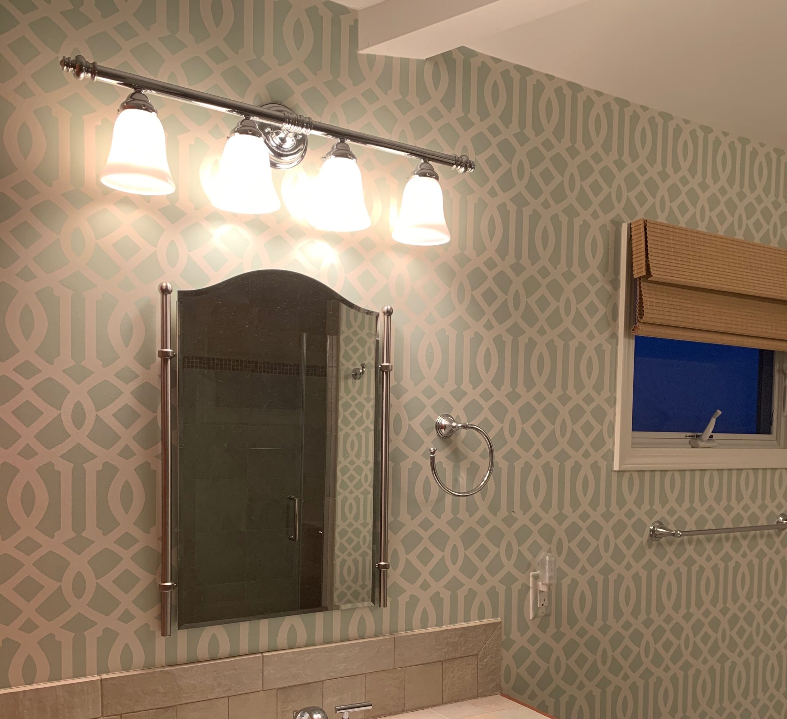 Geometric blue-and-white wallpaper professionally installed in a bathroom in Costa Blanca, Spain.