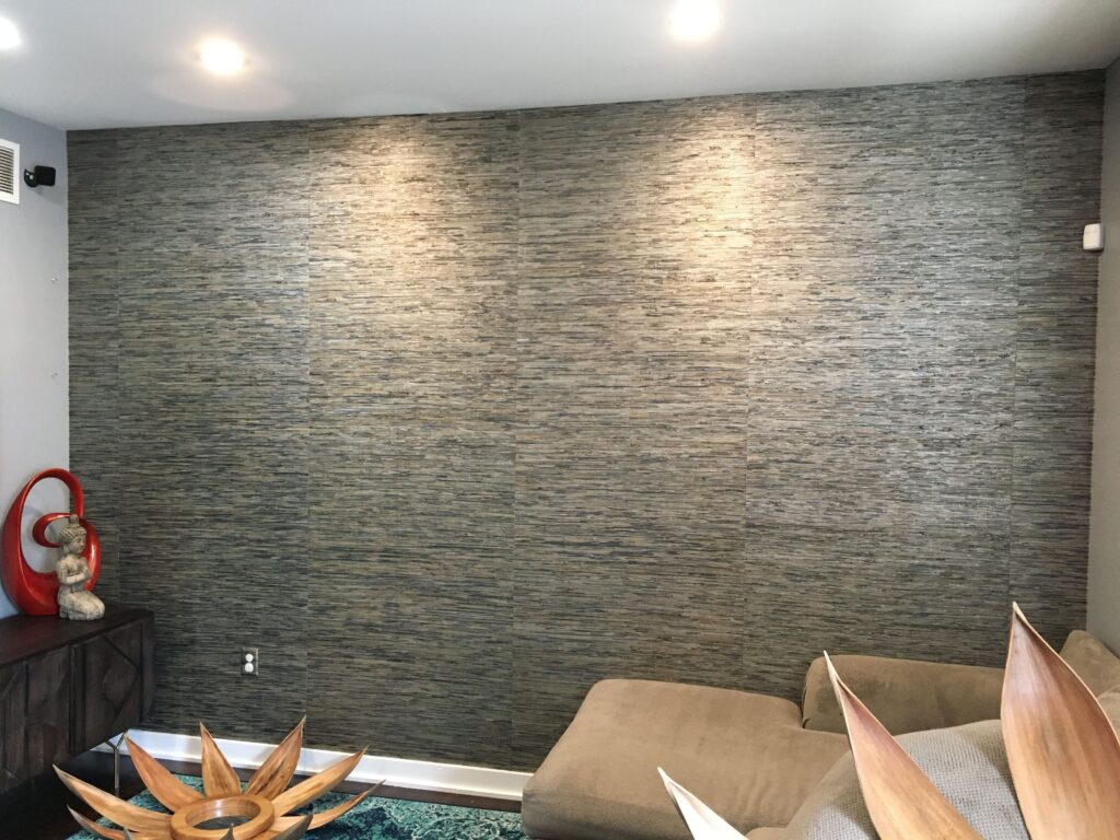 Professional large scale seagrass texture wallpaper installation on a full feature wall in grey and taupe tones in a modern living room, Costa Blanca Spain