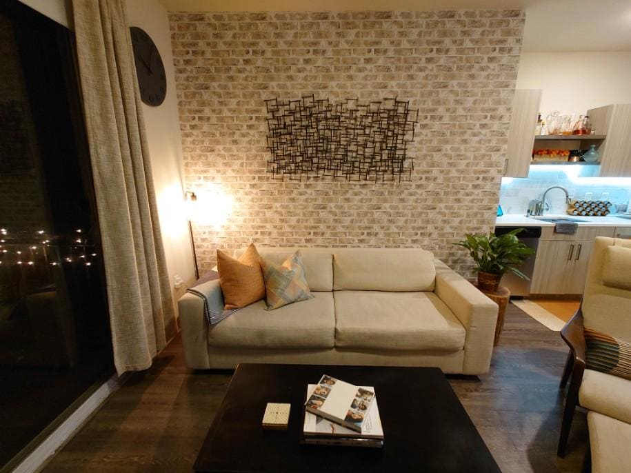 Professional feature wall installation with a white and grey exposed brick effect wallpaper in a warm, modern living room, Costa Blanca Spain