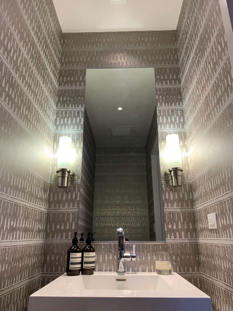 Professional full room wallpaper installation with a taupe and white abstract stripe and dash pattern covering all walls of a luxury powder room, Costa Blanca Spain